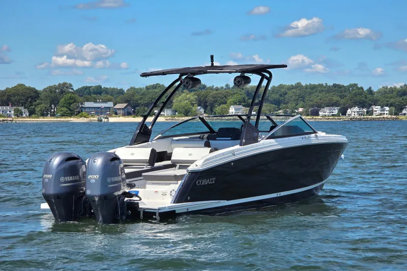Slide: The Image of 2024 Cobalt R8 Outboard boat on water, featuring dual Yamaha engines, scenic shoreline background. - 2