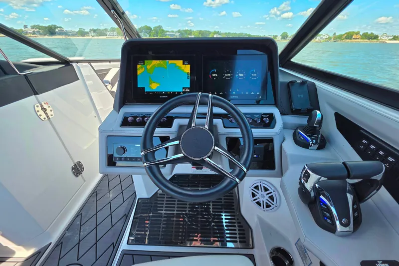 Slide: The Image of 2024 Cobalt R8 Outboard helm with advanced navigation displays and controls, overlooking serene waters. - 28