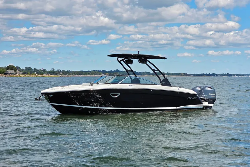 Slide: The Image of 2024 Cobalt R8 Outboard boat on calm water under a partly cloudy sky. - 3