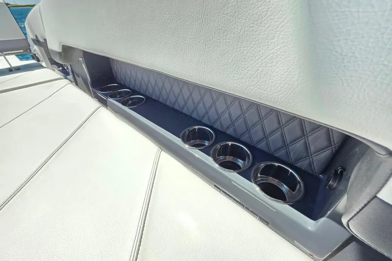 Slide: The Image of 2024 Cobalt R8 Outboard boat interior with cup holders and quilted leather detailing. - 31