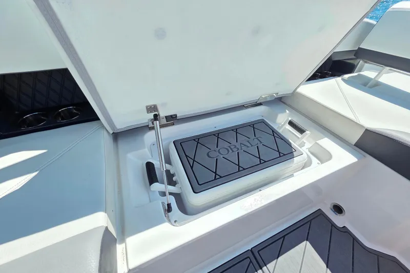 Slide: The Image of 2024 Cobalt R8 Outboard boat storage compartment with open lid, showcasing interior design. - 32