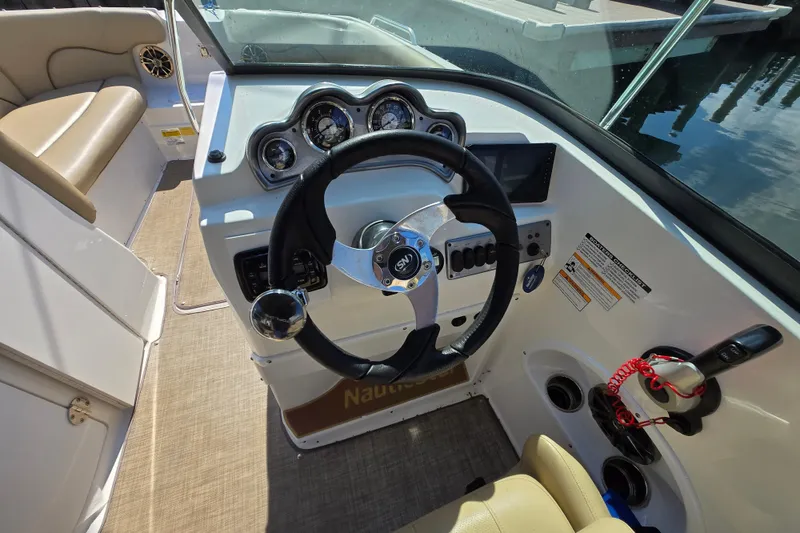 Slide: The Image of 2020 NauticStar 223 DC boat dashboard with steering wheel and gauges. - 11
