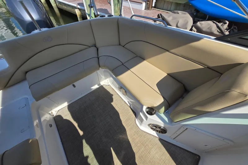 Slide: The Image of 2020 NauticStar 223 DC boat interior with beige seating and carpeted floor. - 12