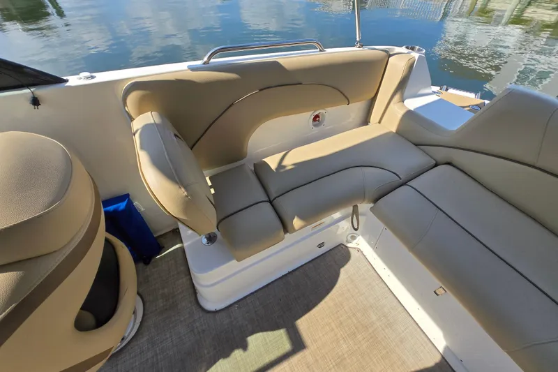 Slide: The Image of 2020 NauticStar 223 DC boat interior with beige seating and water reflection. - 13