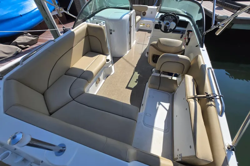 Slide: The Image of 2020 NauticStar 223 DC boat interior with beige seating and steering console. - 2