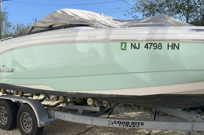 Slide: The Image of 2020 NauticStar 223 DC boat on trailer, covered, with registration NJ 4798 HN. - 4