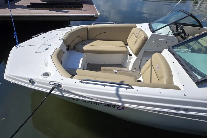 Slide: The Image of 2020 NauticStar 223 DC boat with beige seating, docked on calm water. - 6