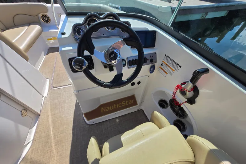 Slide: The Image of 2020 NauticStar 223 DC boat cockpit with steering wheel and controls. - 7