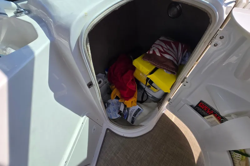 Slide: The Image of Storage compartment of a 2020 NauticStar 223 DC boat with various items inside. - 8