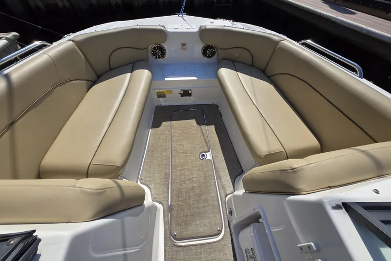 Slide: The Image of 2020 NauticStar 223 DC boat interior with beige seating and carpeted floor. - 9