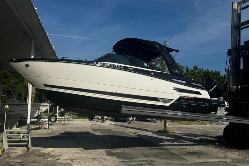 Slide: The Image of 2021 Monterey 255SS Super Sport boat on a lift under clear blue sky. - 2