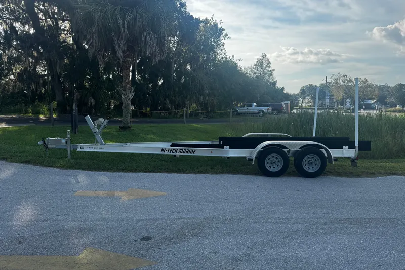 Slide: The Image of Trailer for 2021 Monterey 255SS Super Sport boat parked on grass near trees. - 32