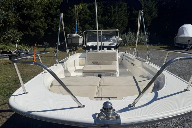 Slide: The Image of 2020 Boston Whaler 170 Montauk boat with spacious deck and seating, parked outdoors. - 4