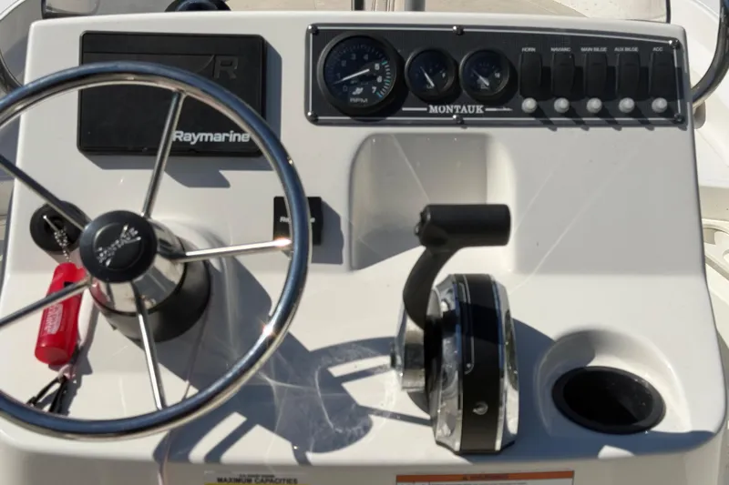 Slide: The Image of Control panel of a 2020 Boston Whaler 170 Montauk boat with steering wheel and gauges. - 5