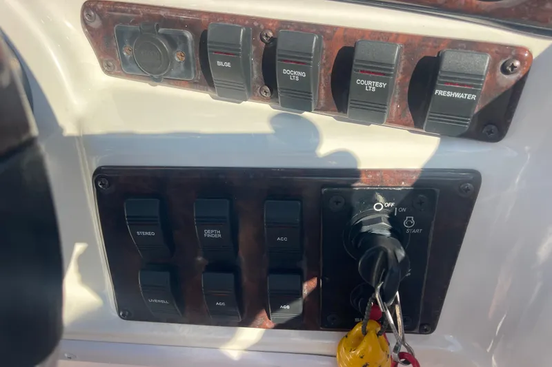 Slide: The Image of Control panel of a 2006 Hurricane FunDeck GS 202 OB boat with various switches and ignition. - 17