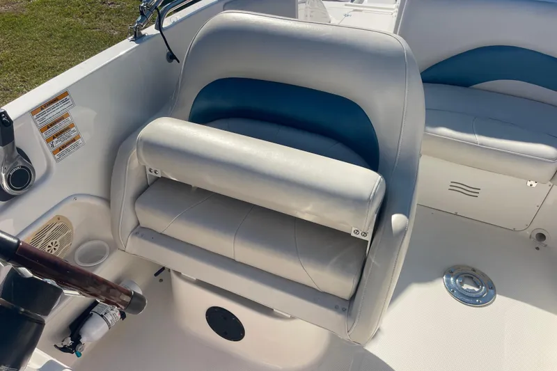 Slide: The Image of Captain's seat on 2006 Hurricane FunDeck GS 202 OB boat, featuring white and blue upholstery. - 25