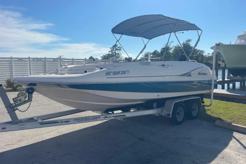 Slide: The Image of 2006 Hurricane FunDeck GS 202 OB boat on trailer, parked near water under blue sky. - 3