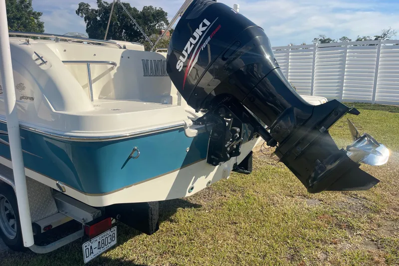 Slide: The Image of 2006 Hurricane FunDeck GS 202 OB with Suzuki outboard motor, parked on grass. - 8