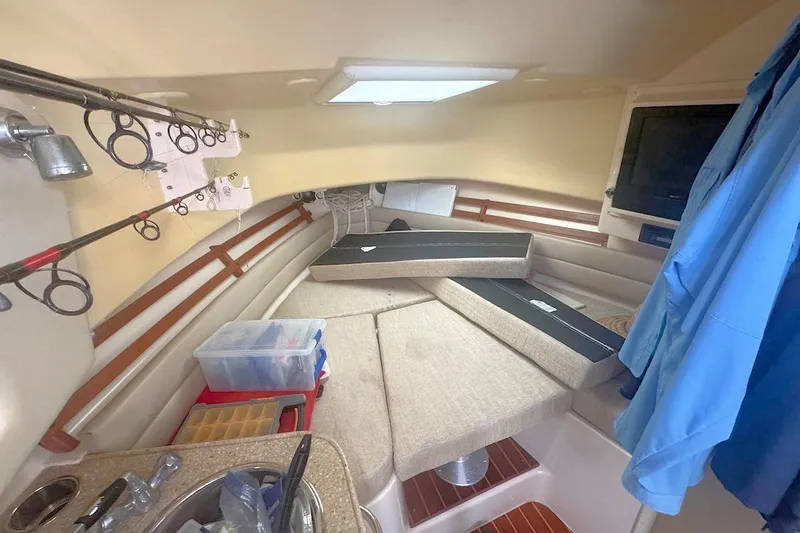 Slide: The Image of 2012 Grady-White Marlin 300 cabin interior with fishing rods and seating area. - 14