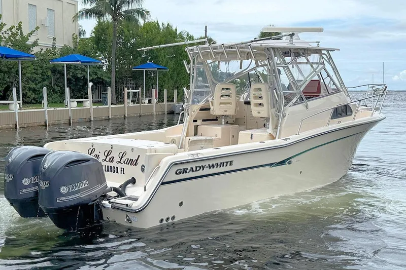 Slide: The Image of 2012 Grady-White Marlin 300 boat with twin Yamaha engines on calm water. - 2