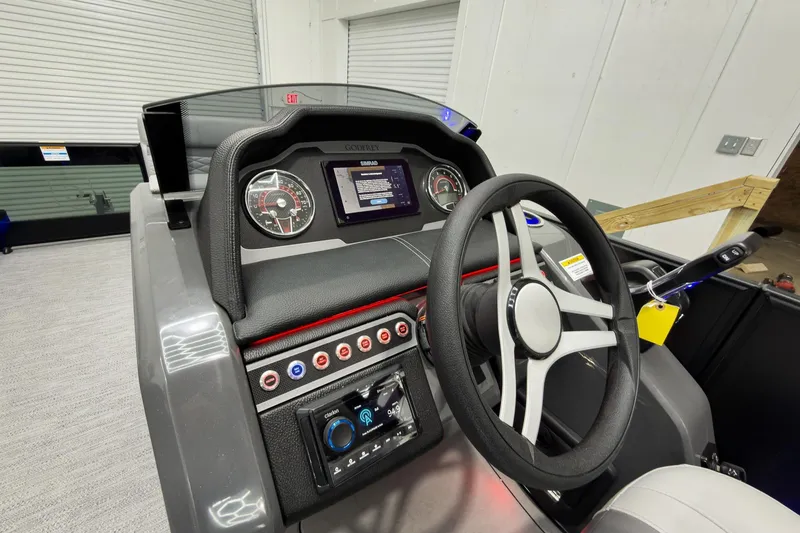 Slide: The Image of 2026 Godfrey Monaco 23' Tritoon dashboard with steering wheel and control panel. - 22