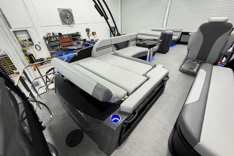 Slide: The Image of 2026 Godfrey Monaco 23' Tritoon with luxurious seating and modern design in a showroom. - 39