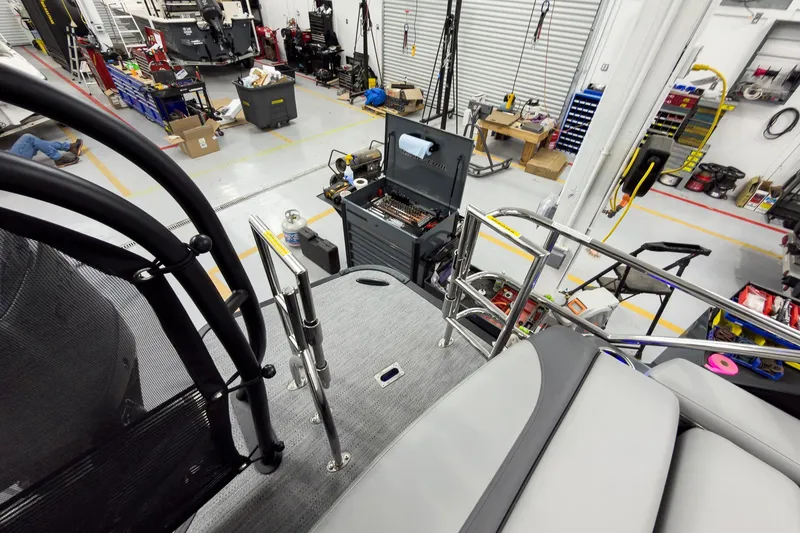 Slide: The Image of Workshop view of 2026 Godfrey Monaco 23' Tritoon assembly, featuring tools and equipment. - 46