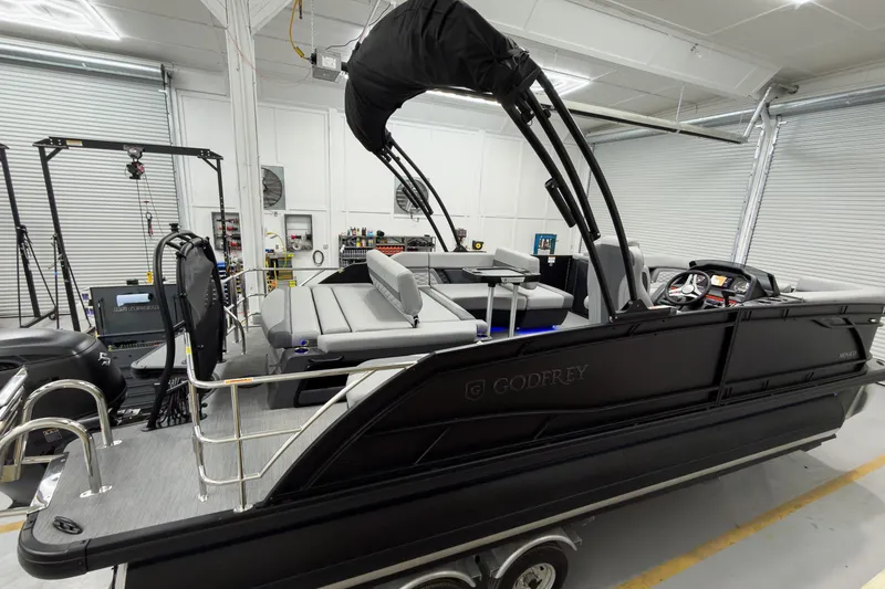 Slide: The Image of 2026 Godfrey Monaco 23' Tritoon with single flip lounge in a showroom. - 5