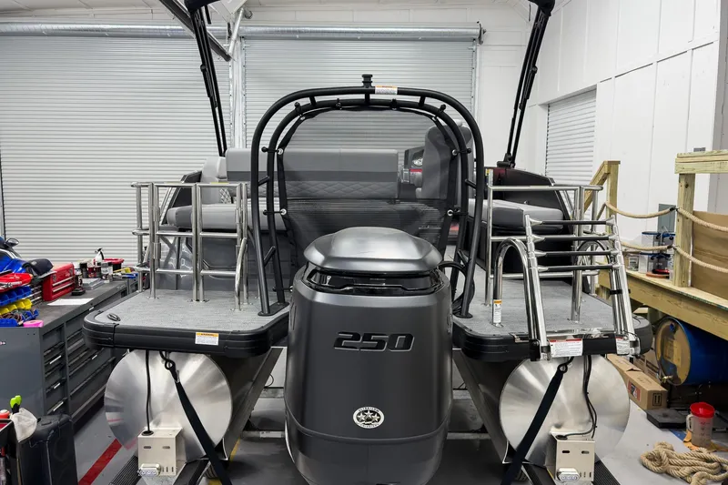 Slide: The Image of 2026 Godfrey Monaco 23' Tritoon boat in a workshop, featuring a 250 HP engine. - 8