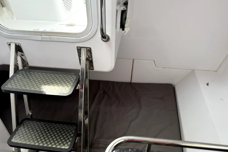 Slide: The Image of 2008 Southport 28 Express boat interior with white seating and helm, docked by the water. - 10