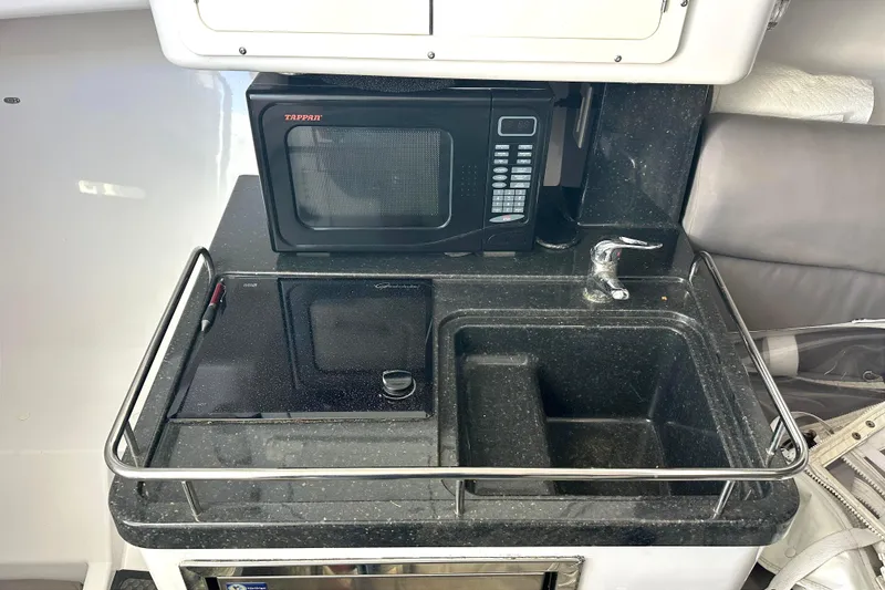 Slide: The Image of Compact kitchenette in a 2008 Southport 28 Express boat with microwave and sink. - 13