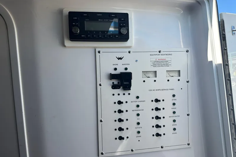 Slide: The Image of Control panel of a 2008 Southport 28 Express boat with various switches and gauges. - 14