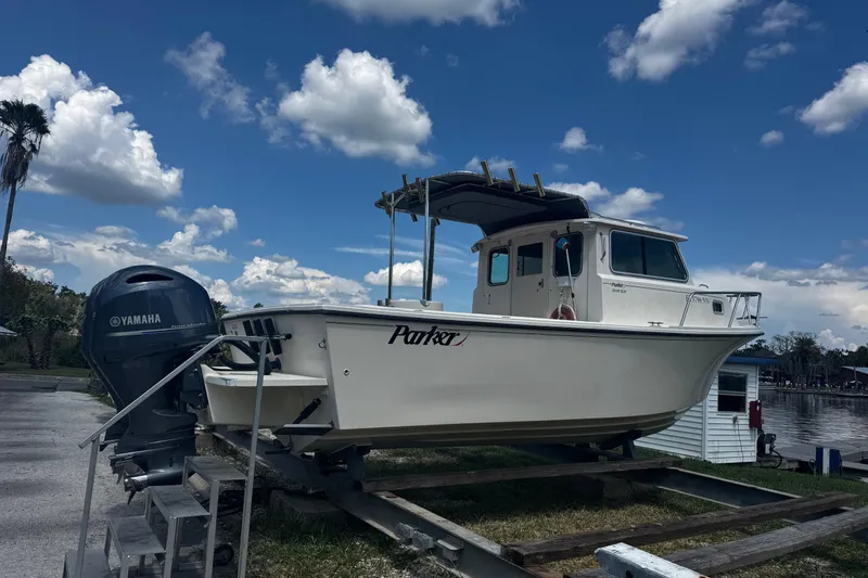 Slide: The Image of 2007 Parker 2520 XLD Sport Cabin boat on trailer with Yamaha engine, under blue sky. - 3