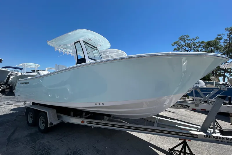 The Image of 2025 Sportsman Heritage 231 Center Console boat on trailer under clear blue sky. - 1