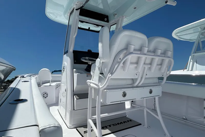 Slide: The Image of 2025 Sportsman Heritage 231 Center Console boat interior with seating and console under clear blue sky. - 11