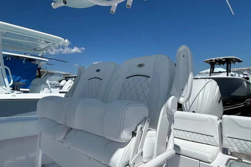 Slide: The Image of 2025 Sportsman Heritage 231 Center Console boat with luxurious seating under clear blue sky. - 12