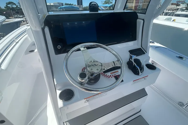 Slide: The Image of 2025 Sportsman Heritage 231 Center Console boat helm with steering wheel and controls. - 17