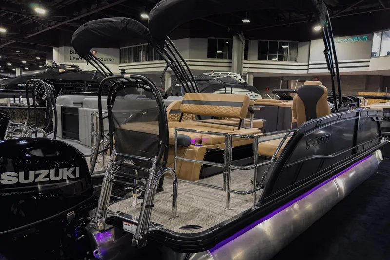 Slide: The Image of 2026 Godfrey Monaco 235 pontoon boat with Suzuki engine, showcased indoors. - 2