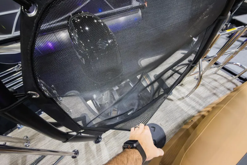 Slide: The Image of Hand adjusting netting on 2026 Godfrey Monaco 235 Single Flip Lounge boat interior. - 31