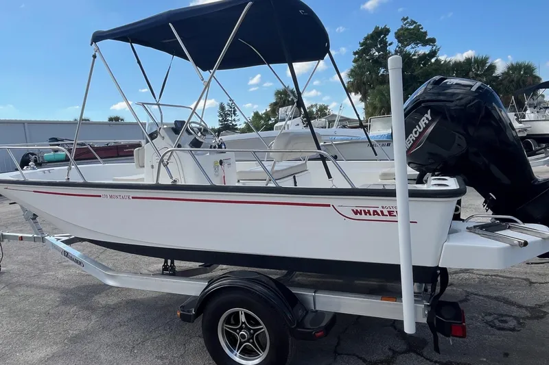 Slide: The Image of 2022 Boston Whaler 170 Montauk boat on trailer with Mercury outboard motor. - 2