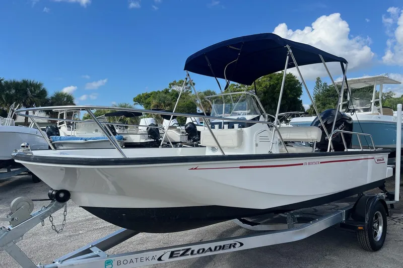 Slide: The Image of 2022 Boston Whaler 170 Montauk boat on trailer, featuring a blue canopy. - 3