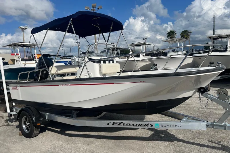 Slide: The Image of 2022 Boston Whaler 170 Montauk boat on trailer under blue sky. - 4
