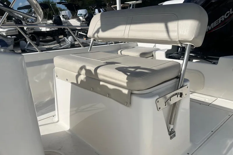 Slide: The Image of 2022 Boston Whaler 170 Montauk boat interior with cushioned seating and stainless steel fixtures. - 9