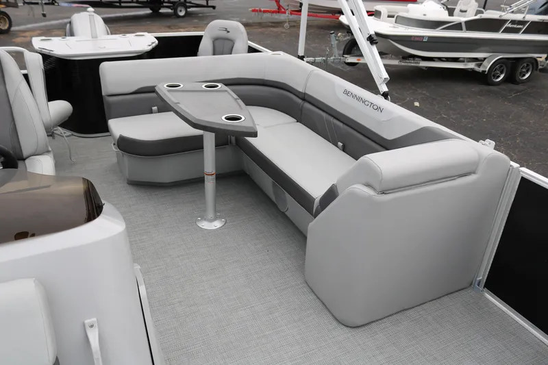 Slide: The Image of Bennington 20SXSNP REAR FISH 2026 boat interior with curved seating and storage compartment. - 21