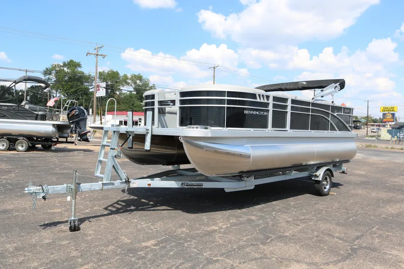 Slide: The Image of 2026 Bennington 20SXSNP REAR FISH pontoon boat on trailer, parked outdoors. - 3