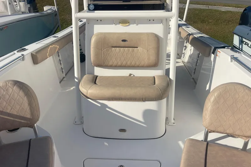 Slide: The Image of 2019 Sportsman Open 242 Center Console boat interior with beige seating. - 16