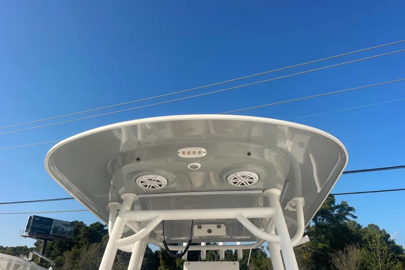 Slide: The Image of 2019 Sportsman Open 242 Center Console T-top against clear blue sky. - 18
