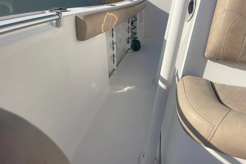 Slide: The Image of 2019 Sportsman Open 242 Center Console interior with beige seating and white deck. - 20