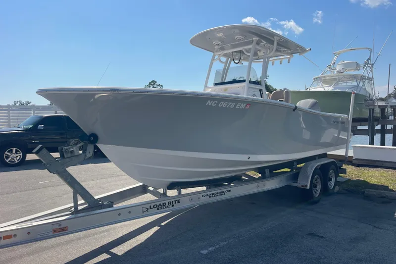 Slide: The Image of 2019 Sportsman Open 242 Center Console boat on trailer, parked outdoors. - 3
