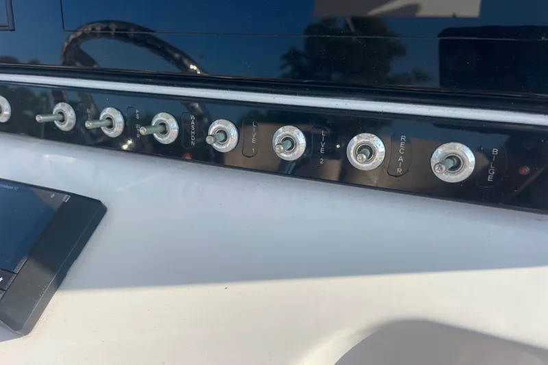 Slide: The Image of Control panel of a 2019 Sportsman Open 242 Center Console boat with toggle switches. - 35